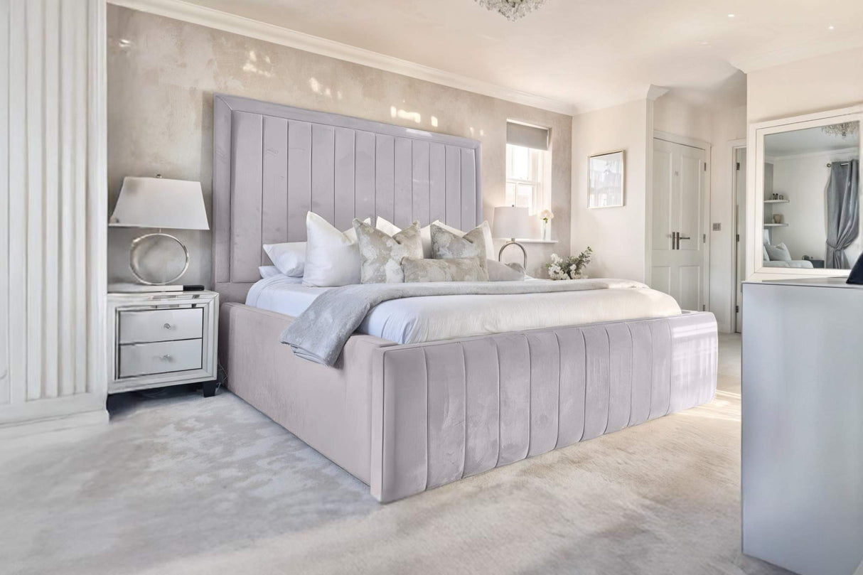 Modern bedroom with gray upholstered bed and decorative elements.